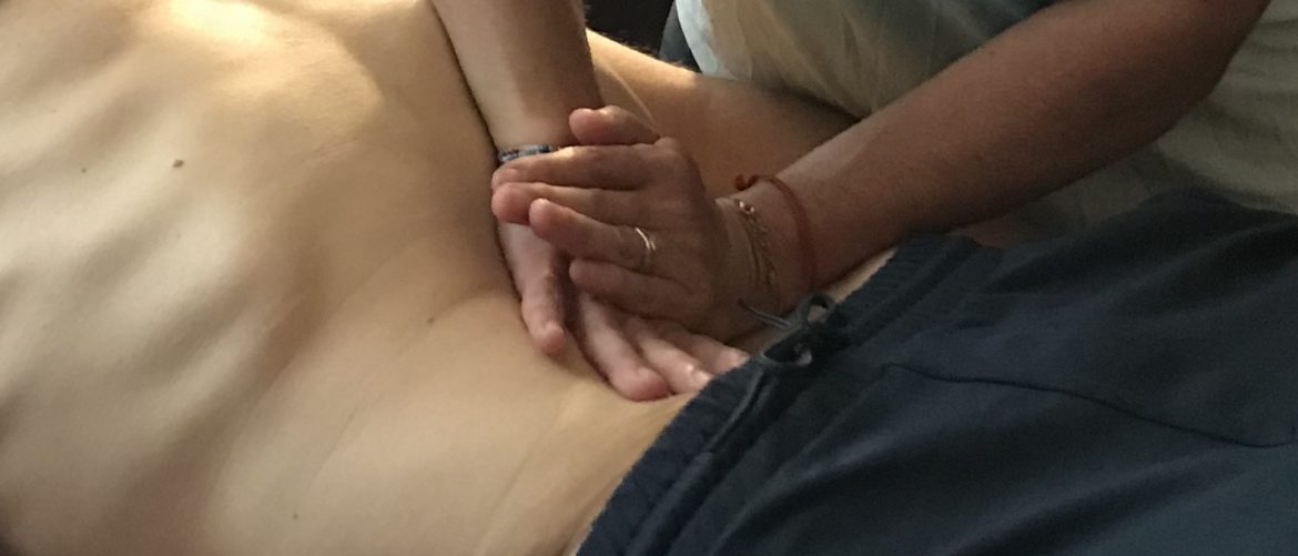 Praticienne qui travaille sur le ventre d'un patient lors d'un post-grade à l'École Ling
